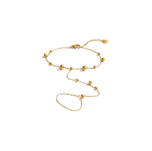 Gold beaded hand chain with delicate beads and adjustable extender.